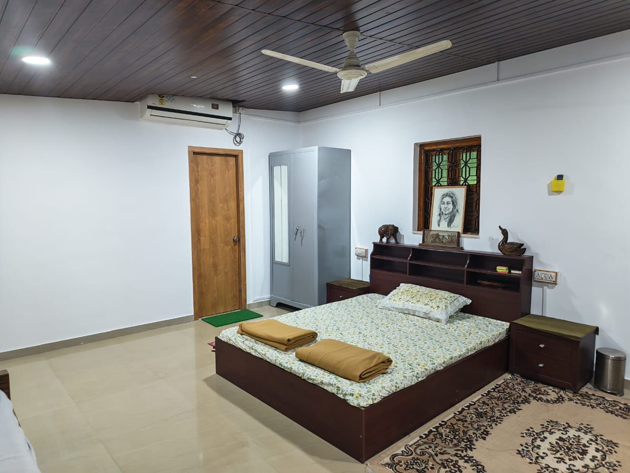 Bedroom with a double bed, wooden ceiling and carved window