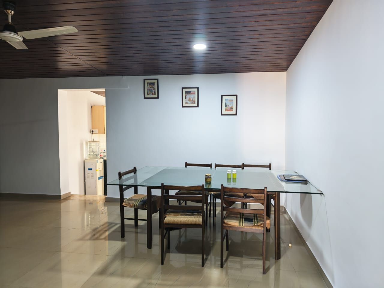 Dining room with a glass table and chairs, and the kitchen