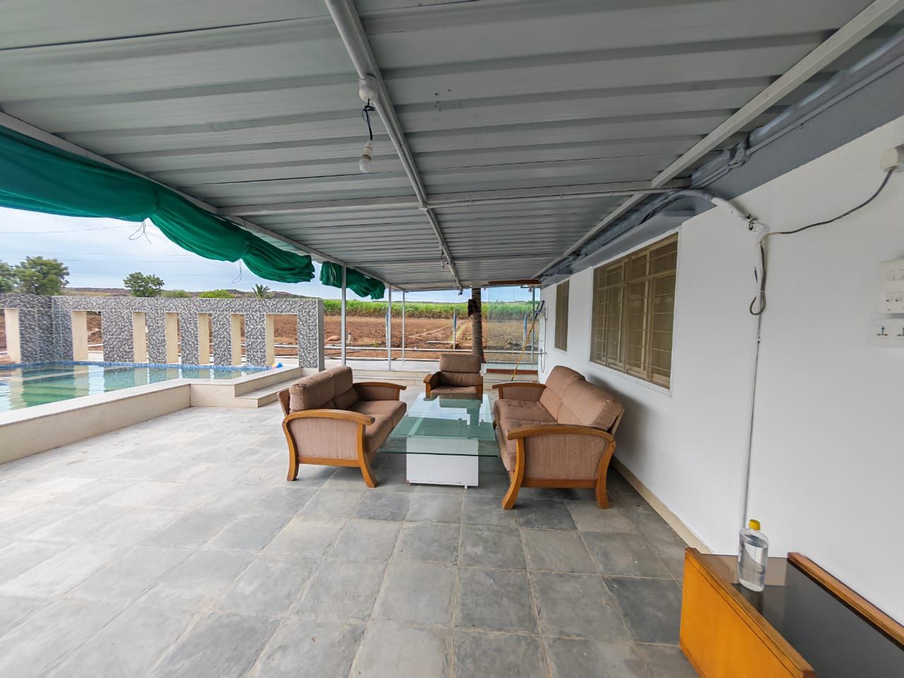 Covered veranda with sofas beside the swimming pool